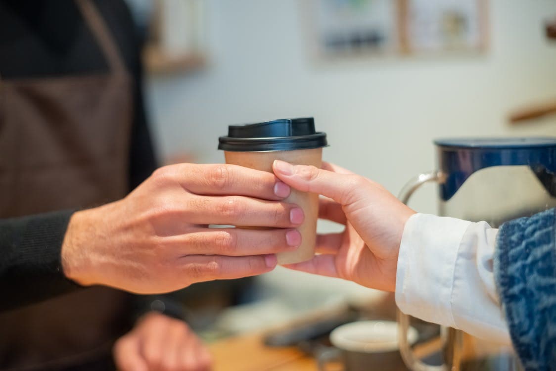 Barista entregando café a cliente